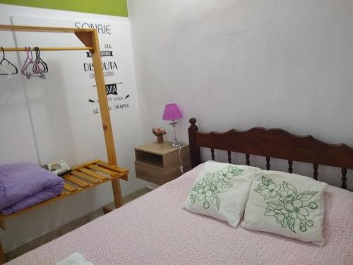 ein Schlafzimmer mit einem Bett und einem Tisch mit einer Lampe in der Unterkunft Naiguata in Zárate