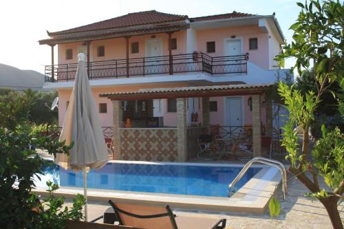 a house with a swimming pool and an umbrella at Evan's Studios in Alykes