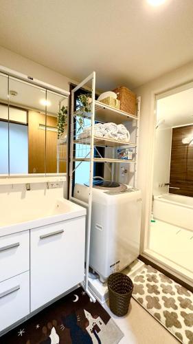 a kitchen with white cabinets and a refrigerator at 池袋新宿涩谷三地埼京线9分至16分直达 可住2人至10人 星の園 in Tokyo