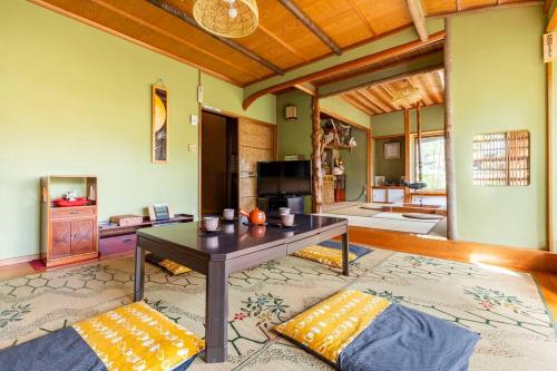 sala de estar con mesa y sofá en 一組限定の貸切空間 Guest House Engiya en Matsumoto