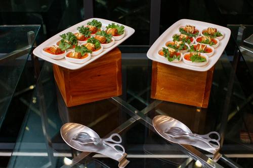 two plates of food on a glass table with shoes at THE 1O1 Jakarta Airport CBC in Tangerang