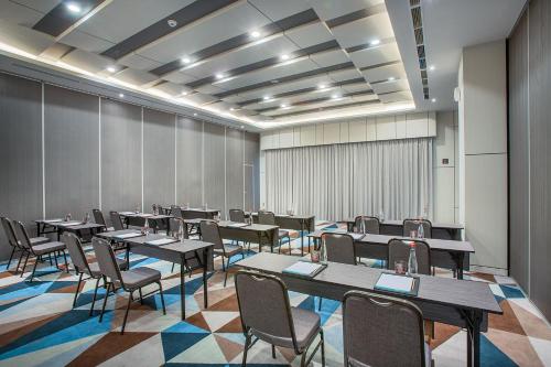 a large room with tables and chairs in it at THE 1O1 Jakarta Airport CBC in Tangerang
