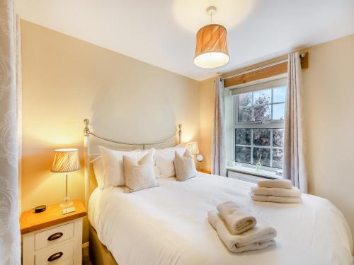 a bedroom with a white bed and a window at Forge Cottage in Carlton