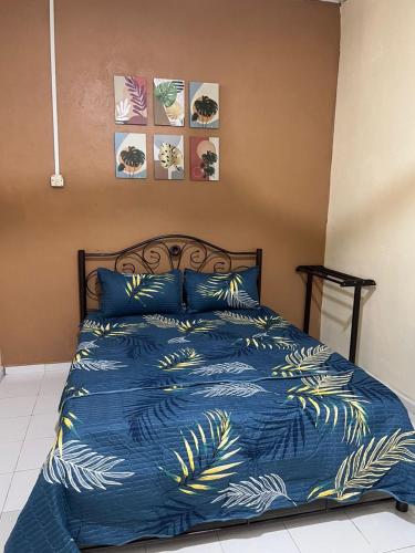 1 cama con edredón azul y almohadas azules en HOMESTAY ADRA LEBAN CHONDONG ROMPIN, en Kuala Rompin