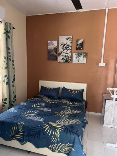 1 dormitorio con 1 cama con edredón azul en HOMESTAY ADRA LEBAN CHONDONG ROMPIN, en Kuala Rompin
