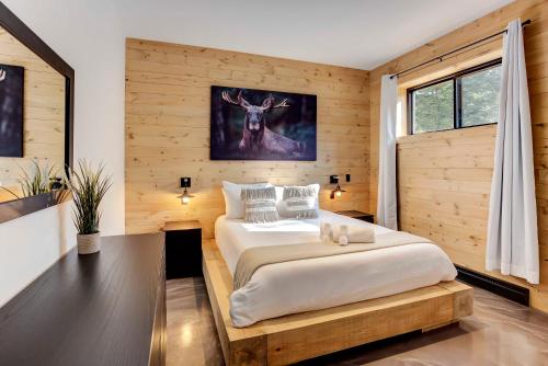 a bedroom with a bed and a deer on the wall at Tremblant chalet O-Spa in Lac-Superieur