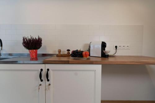 a kitchen with white cabinets and a counter with a toaster at Apartament przy Czarnej Bramie in Kłodzko