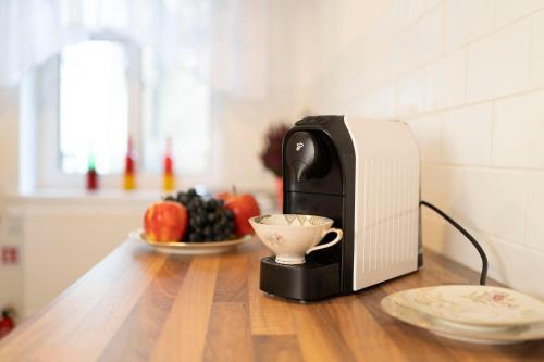 a toaster sitting on a table with a bowl of fruit at Apartament przy Czarnej Bramie in Kłodzko