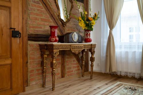 a table with a clock on it next to a brick wall at Apartament przy Czarnej Bramie in Kłodzko