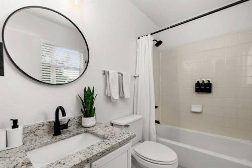 bagno bianco con lavandino e specchio di Golden Chest - Modern - UTSA Central - Fast WiFi a San Antonio