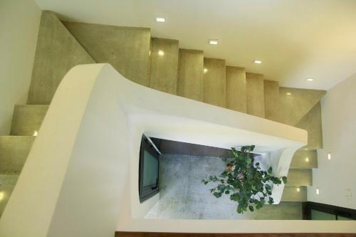 eine Treppe mit einem Fernseher und einer Topfpflanze in der Unterkunft Boom Casa Homestay in Hue