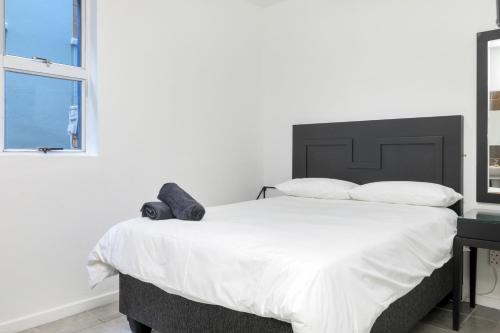 a bedroom with a large bed with a teddy bear on it at Inn & Out Express Sea Point in Cape Town