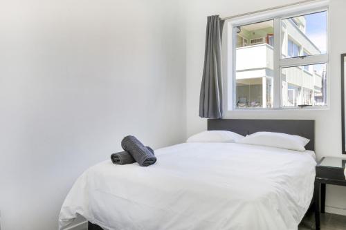a white bed in a room with a window at Inn & Out Express Sea Point in Cape Town