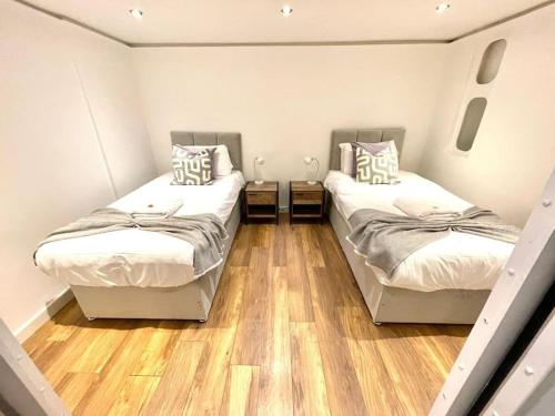 2 Betten in einem Zimmer mit Holzböden in der Unterkunft HISTORICAL BUILDING / Cozy Basement Apt / Central in Cambridge