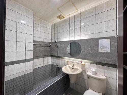 a bathroom with a sink and a toilet and a tub at 町宿溫泉旅館 in Jiaoxi