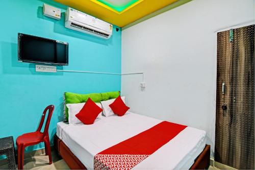 a bedroom with a bed and a tv on the wall at OYO Flagship Hotel Daffodil Lodging and Boarding in Jānla
