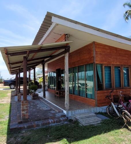 a house with a covered porch with motorcycles parked outside at PULANG RESORT in Setiu