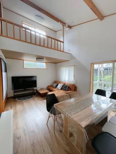 a living room with a couch and a table at HAKUBA House LuckyStar5 next to shuttle bus station ,711 ,restaurants Modern Chalet in Hakuba
