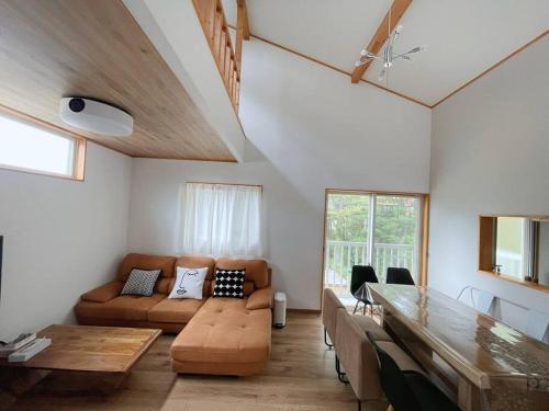 a living room with a couch and a table at HAKUBA House LuckyStar5 next to shuttle bus station ,711 ,restaurants Modern Chalet in Hakuba