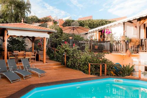 ein Haus mit einem Pool und einer Terrasse in der Unterkunft Villa - Bleu Mer Caraïbes in Case-Pilote