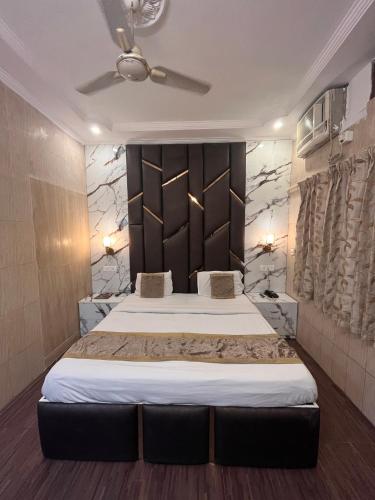 a bedroom with a large bed with a black headboard at Hotel Embassy in Dehradun
