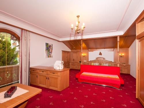 a bedroom with a red bed and a table at Adlerhorst , Gstan 31 in Finkenberg