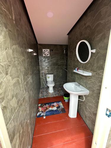 een badkamer met een wastafel en een toilet bij ปลายเขื่อนแคมป์ปิ้ง in Sirindhorn