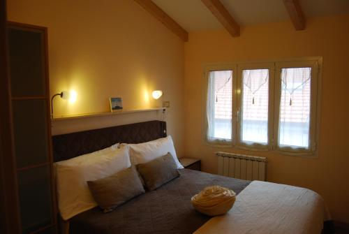 a bedroom with a large bed with two windows at Burlamacco Gold in Viareggio