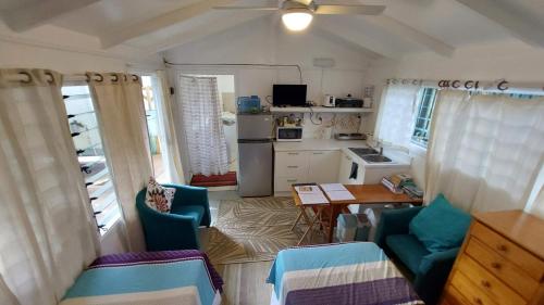 eine Küche mit blauen Stühlen und einem Tisch im Zimmer in der Unterkunft Are Tamareni 2BR Beach Cottage or River Studio in Avarua