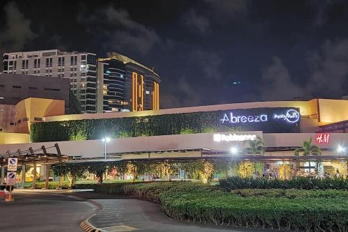 達沃市的住宿－Davao City Serenity on Seventeenth One-Bedroom Condo beside Shopping Malls with Seaview and City view，一座建筑物,晚上在建筑物的一侧有标志
