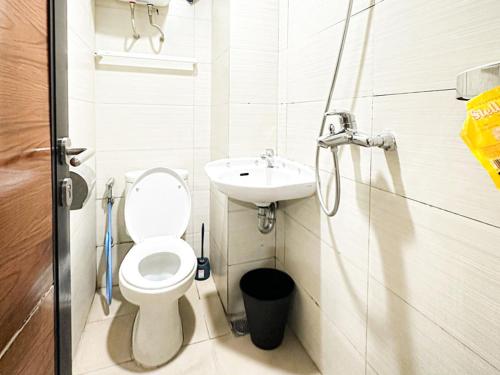 een kleine badkamer met een toilet en een wastafel bij Gateway Pasteur Apartment by RumahKu in Bandung