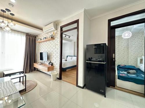 een woonkamer met een grote glazen deur naar een slaapkamer bij Gateway Pasteur Apartment by RumahKu in Bandung