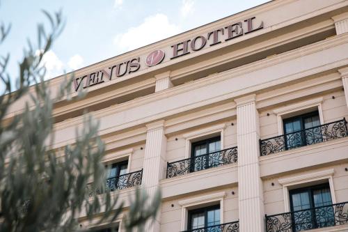 een gebouw met een bord erop bij Venus Hotel in Pristina