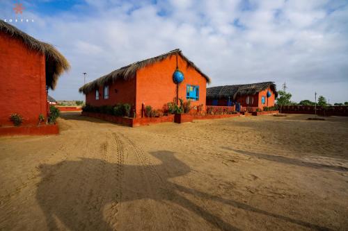 a group of buildings on a dirt road at Zostel Sam Desert (Jaisalmer) in Sām