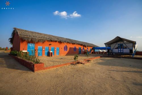 an orange and blue building with a roof at Zostel Sam Desert (Jaisalmer) in Sām