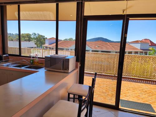 a kitchen with a counter with a microwave on top of it at Tuggeranong Short Stay #08C - Sleeps 6 in Canberra