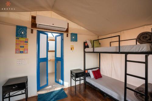 a room with two bunk beds and a tv at Zostel Sam Desert (Jaisalmer) in Sām