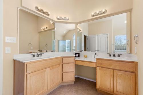 a bathroom with two sinks and a large mirror at Sleep on the Cloud - 5 Bedrooms - Corner Lot in San Antonio