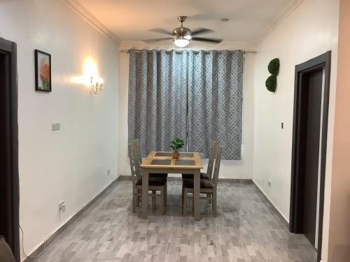 ein Esszimmer mit einem Tisch und einem Deckenventilator in der Unterkunft Fine Boy Villa, Luxe Two-Bedroom Apartments in Tema Community 25 in Tema