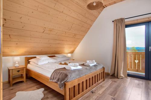um quarto com uma cama e uma grande janela em Domek Asina Chata Zawoja em Zawoja