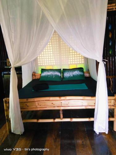 a bed in a room with a mosquito net at Sanctuaria Treehouses Busuanga in Busuanga