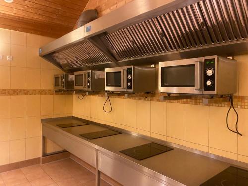 a kitchen with three microwaves on the wall at Wohnwagen auf dem Wulfenerhals in Fehmarn