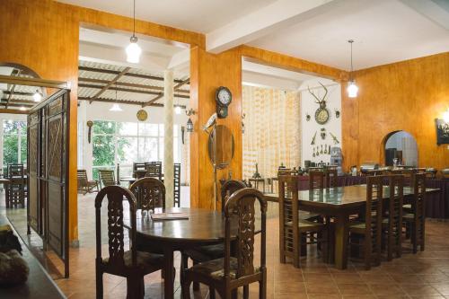 a dining room with wooden walls and tables and chairs at MF Holiday Bungalow in Bandarawela