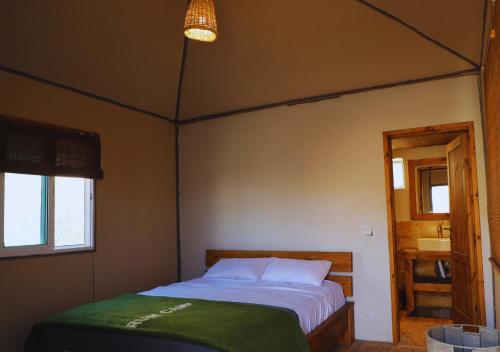 a bedroom with a bed and a window and a sink at Rum Planet Camp in Wadi Rum
