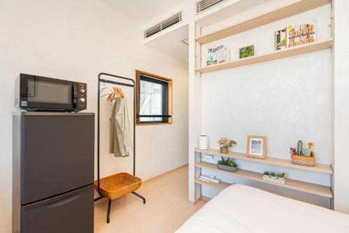 a room with a refrigerator and a tv in it at ZAITO Tokyo Narihira Hotel　押上駅から徒歩八分ホテル in Tokyo