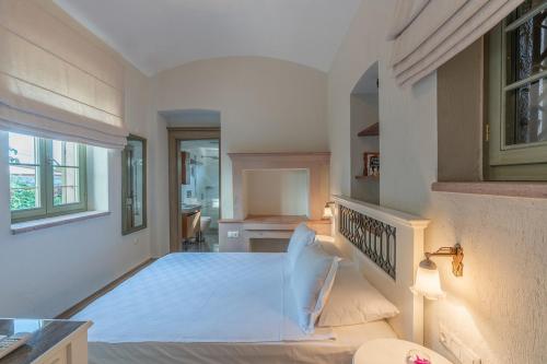 een witte kamer met een bed en een raam bij Elia Hotel Cunda by Ortunc in Ayvalık
