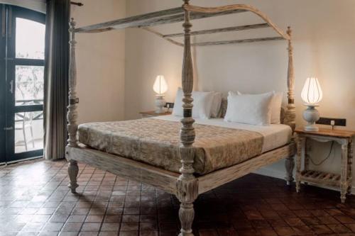 - une chambre avec un lit à baldaquin et 2 lampes dans l'établissement Naomi Beach Resort - Adults only, à Weligama