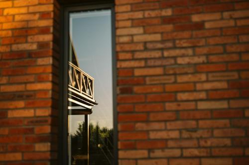 a window of a brick building with a reflection in it at Czas na Las in Żarnowska