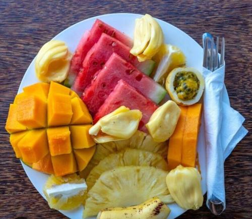 a plate of fruits and vegetables on a table at Sea Yo Villa - Hikkaduwa in Hikkaduwa