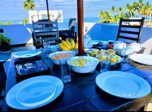 a blue table with plates and bowls of food on it at Sea Yo Villa - Hikkaduwa in Hikkaduwa